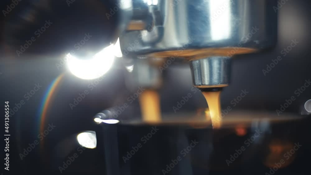 close-up of coffee preparation in a coffee machine, macro video of coffee drops pouring into a cup. Fragrant drink in the morning.