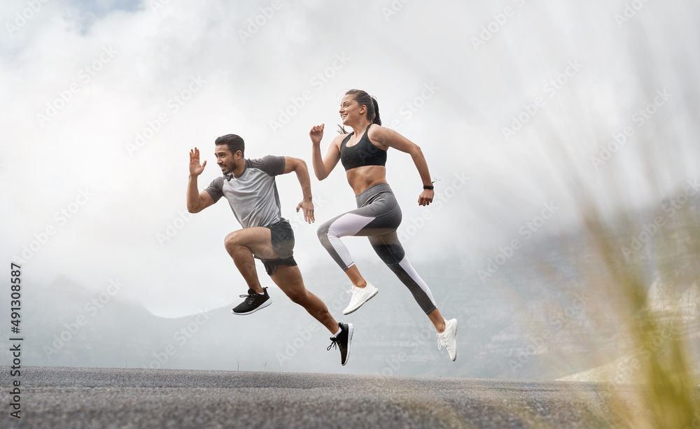 Started with a mile, now were at marathons. Shot of a sporty young man and woman running together outdoors. Started with a mile, now were at marathons. Shot of a sporty young man and woman running together outdoors.