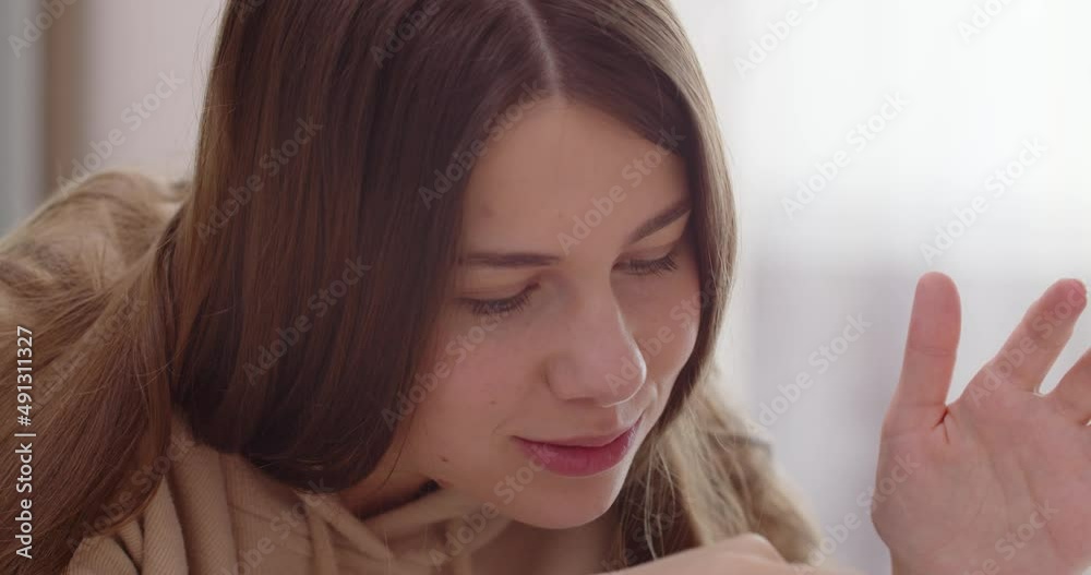 Maternal love. Caring mother smiles at newborn baby and plays with her.