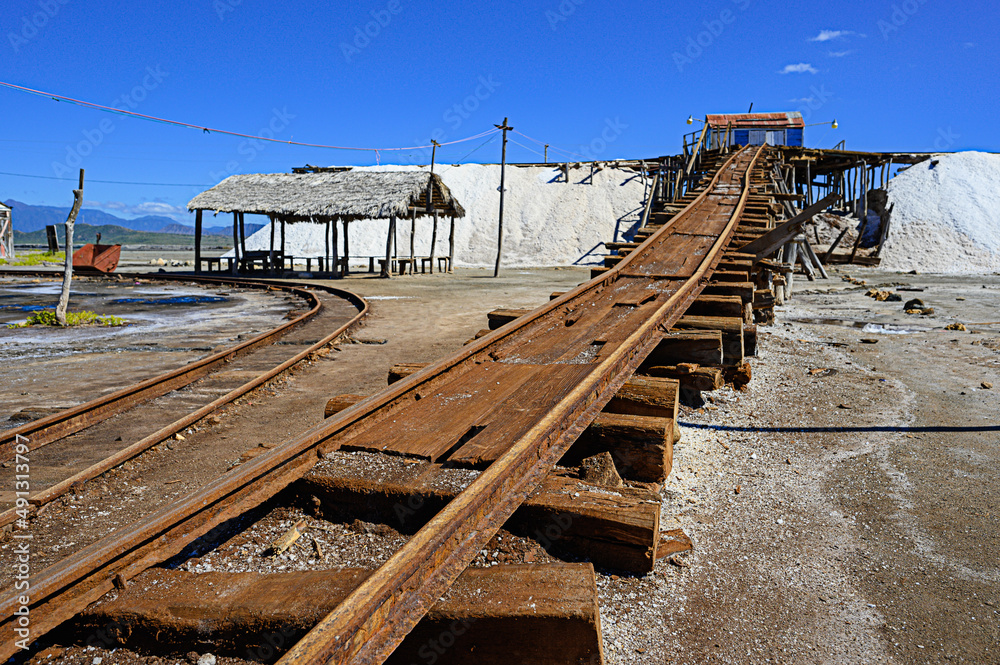 Naklejka premium Vintage railway to salt mountain. Old rails at salt factory. Sea salt. Blue sky