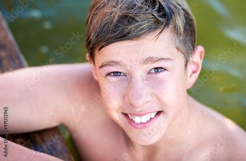 Simple joys. Portrait of a teenage boy having a swim in a lake. © Marius V/peopleimages.com