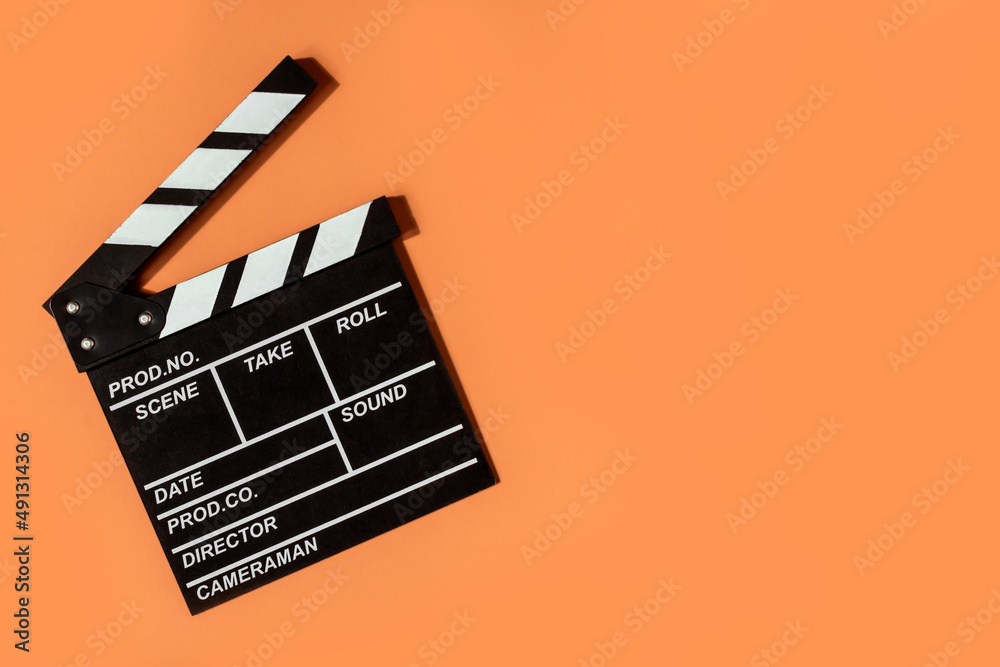 clapperboard shooting video movies orange background copy space