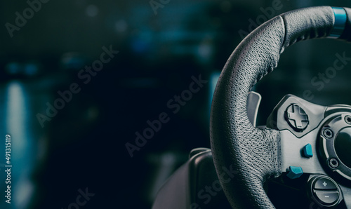 Technology, gaming, entertainment and people concept - young man playing car racing video game at home and steering wheel