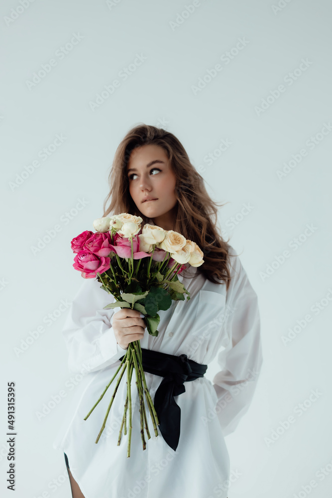 Beautiful girl model with a bouquet of roses. Spring Lady. on light background. Female body and style concept. Advertisement or clothes sale design. Beautiful girl model with a bouquet of roses. Spring Lady. on light background. Female body and style concept. Advertisement or clothes sale design.