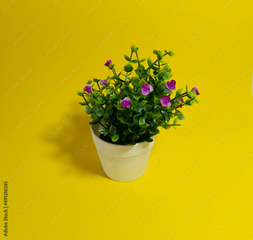 Artificial flower ornament on yellow background. spring concept.