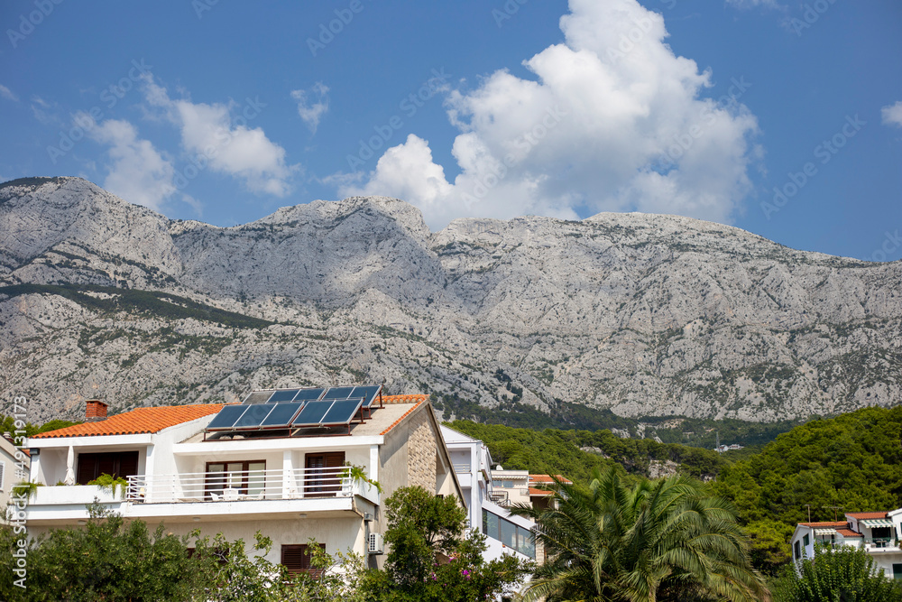 House with solar panels on the roof on the mountains background in Croatia