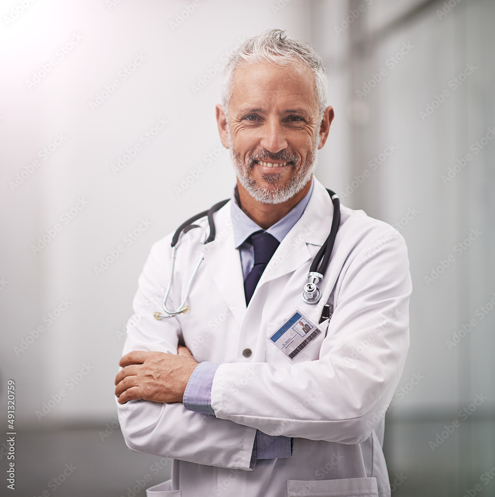 Your health is my happiness. Cropped portrait of a mature doctor standing with his arms folded in the hospital corridor. Your health is my happiness. Cropped portrait of a mature doctor standing with his arms folded in the hospital corridor.