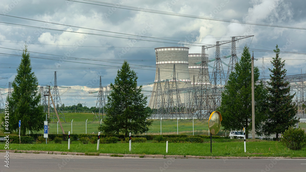 Characteristic elements of the infrastructure of a nuclear power plant against the background of a summer natural landscape