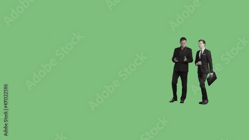 Two men in business clothes are walking and discussing. Perspective view. 85mm lens. Alpha channel included