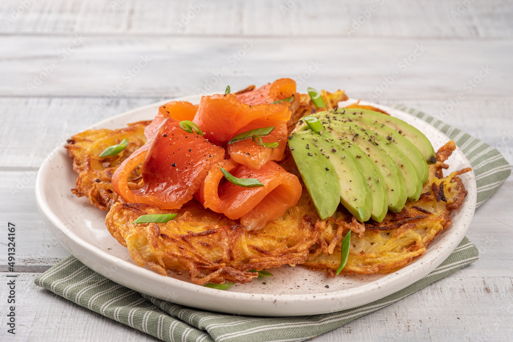 Fried potato pancakes with salmon and sour cream, fritter, roesti, golden crispy crust. Traditional delicious food, breakfast Fried potato pancakes with salmon and sour cream, fritter, roesti, golden crispy crust. Traditional delicious food, breakfast