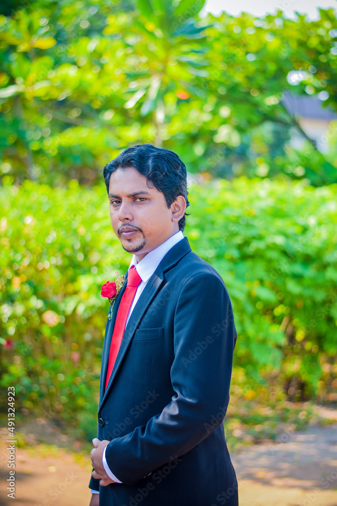 A handsome young man sitting with a green background A handsome young man sitting with a green background