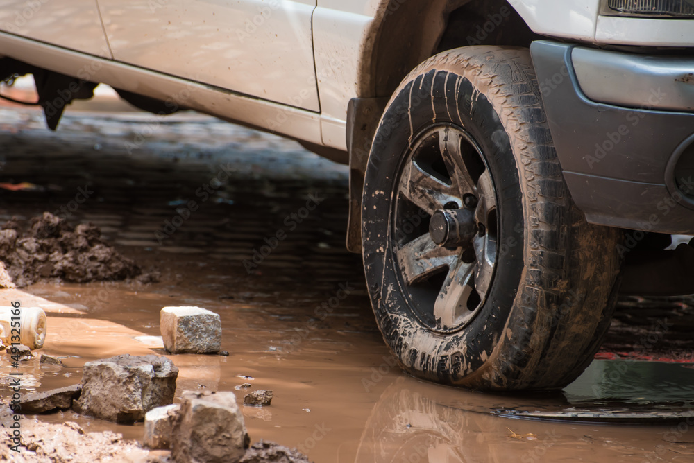 car wheel on mud-stained asphalt
