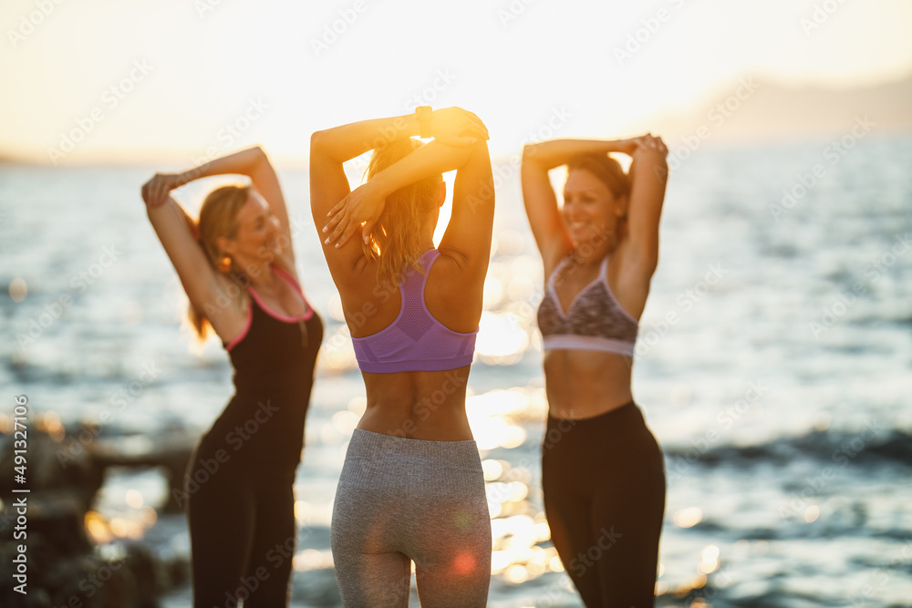 Three Women Doing Outdoors Workout Near The Sea