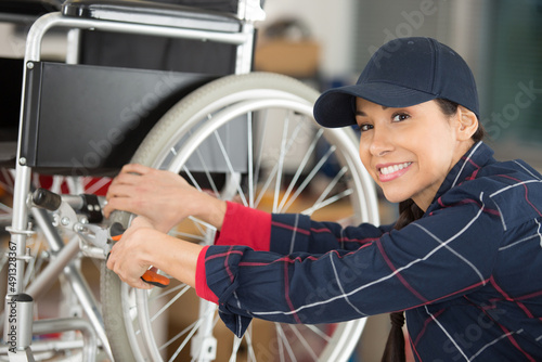 woman is repairing a wheelchair in garage