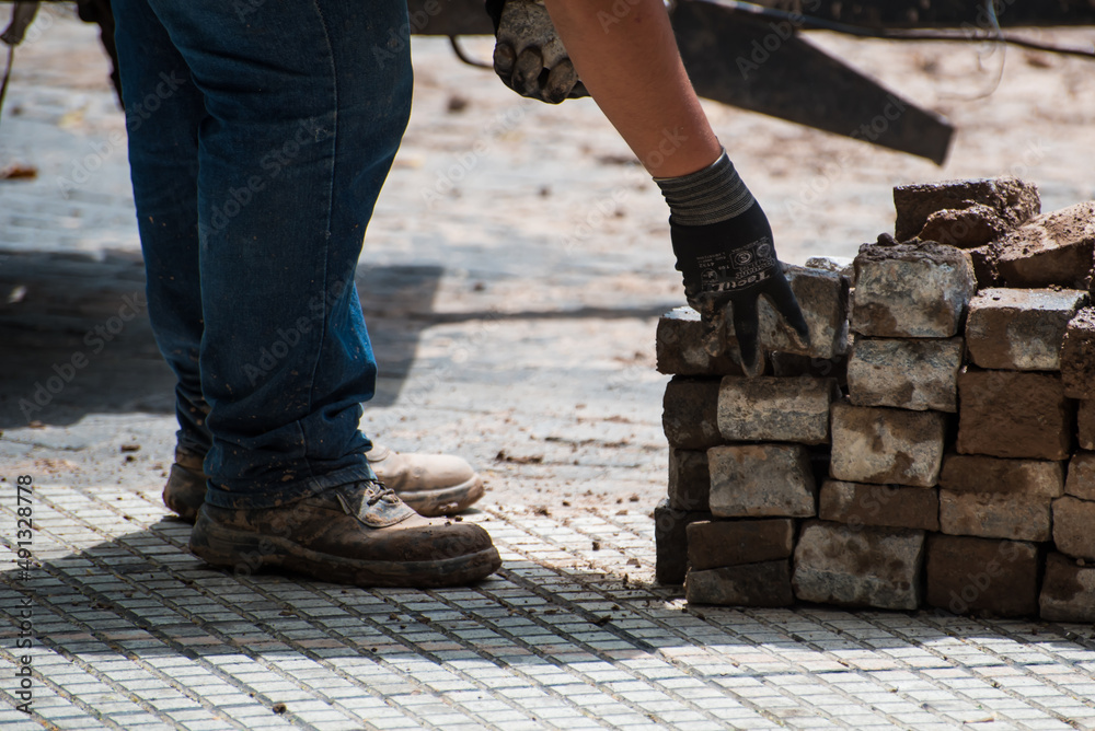 construction worker moving stone debris by hand construction worker moving stone debris by hand