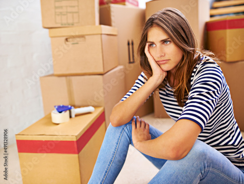 Will these boxes ever end. Shot of an attractive young woman busy moving house. photo