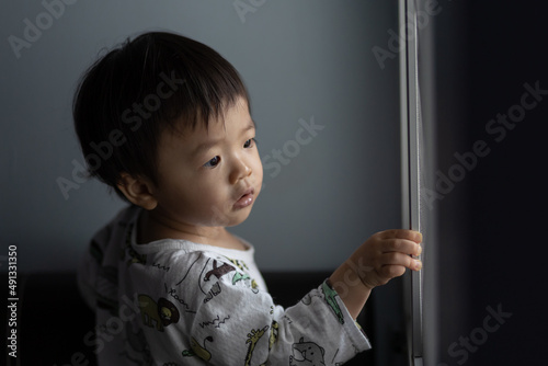 cute Asian Chinese 1 years old Asian Chinese baby boy playing around windows. photo