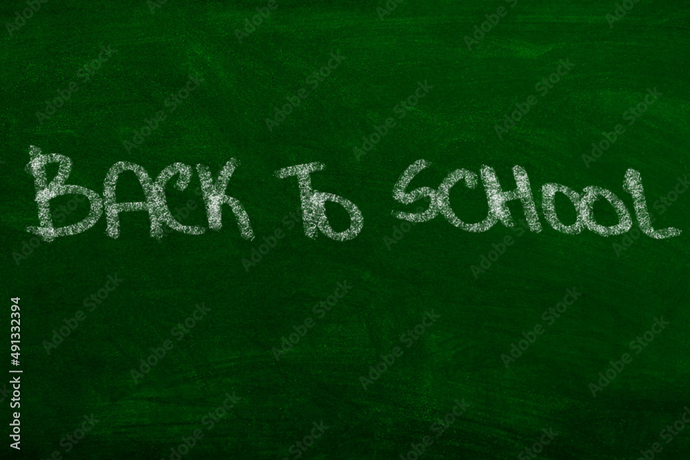 Back to School sign on greenboard written with chalk handwritten sign Back to School sign on greenboard written with chalk handwritten sign