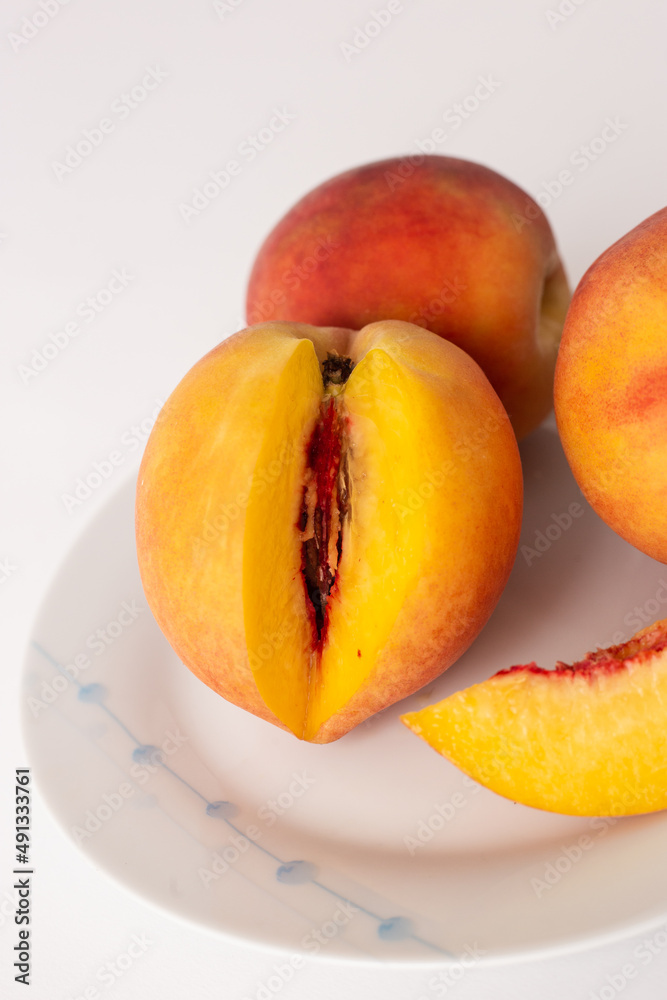 ripe peaches on a plate, white background