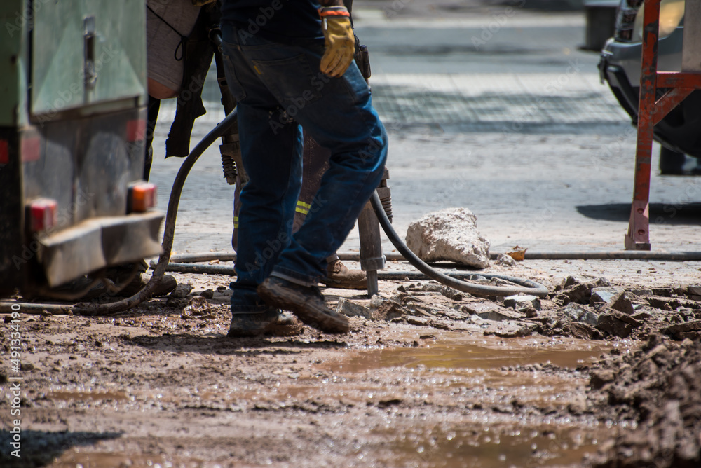 construction workers walking through the rubble of a muddy street construction workers walking through the rubble of a muddy street