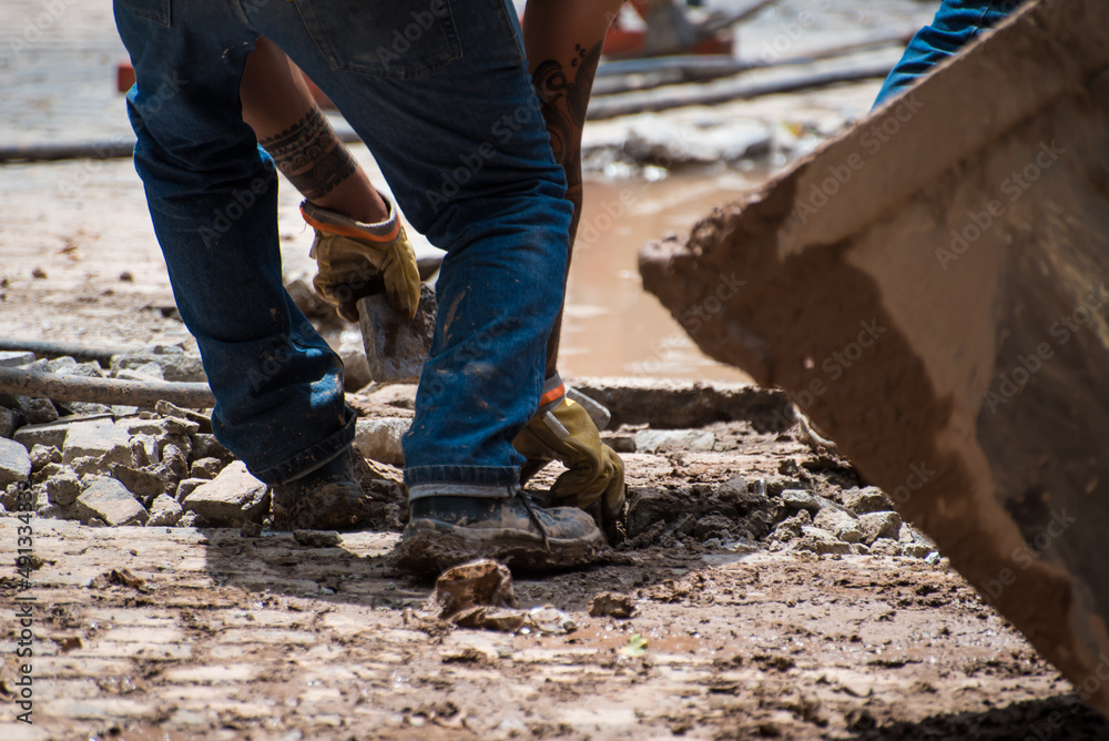 construction worker moving stone debris by hand construction worker moving stone debris by hand
