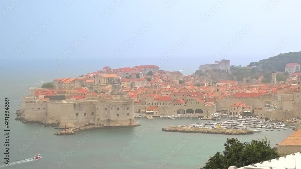 panorama of old medieval harbour on top walls of Dubrovnik city in Croatia. Dubrovnik historic city of Croatia in Dalmatia. UNESCO Venetian architecture. Fort Lovrijenac fortress on background. panorama of old medieval harbour on top walls of Dubrovnik city in Croatia. Dubrovnik historic city of Croatia in Dalmatia. UNESCO Venetian architecture. Fort Lovrijenac fortress on background.