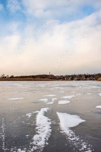 Winter lake , frozen water , snow on the ice , lake frozen . Winter morning , landscape with snow and ice , sunrise over the lake . Beautiful sky and clouds . Sun through the clouds  © Александр Рябинин
