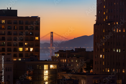 Golden Gate Bridge at sunset seen through buildings, Nob Hill, San Francisco, California photo