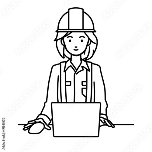 デスクで座ってPCを使っている工事現場の女性