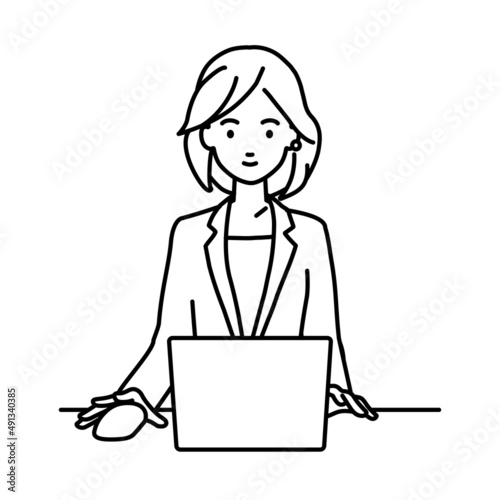 デスクで座ってPCを使っているスーツの女性