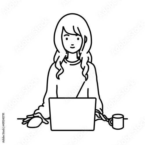デスクで座ってPCを使っているリモートワークの女性