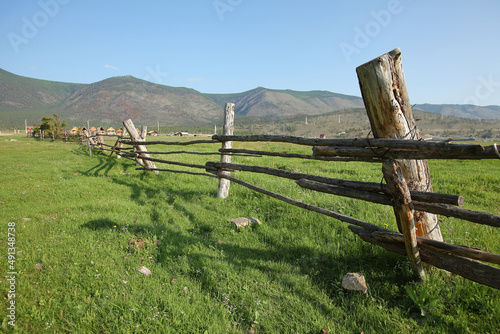Landscape,wooden fence,rustic fence against the background of hills and blue sky,