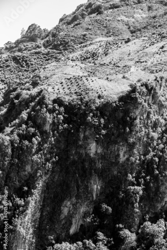 Dramatic black and white image of agricultural fields and farms high on the cliff of the Caribbean mountains, in the Dominican Republic.