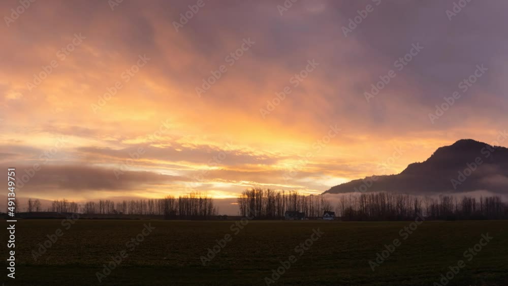 Cinemagraph. Farm lands and Canadian Mountain Nature Landscape. Dramatic Winter Sunset. Located near Chilliwack and Abbotsford, British Columbia, Canada. Cinemagraph. Farm lands and Canadian Mountain Nature Landscape. Dramatic Winter Sunset. Located near Chilliwack and Abbotsford, British Columbia, Canada.
