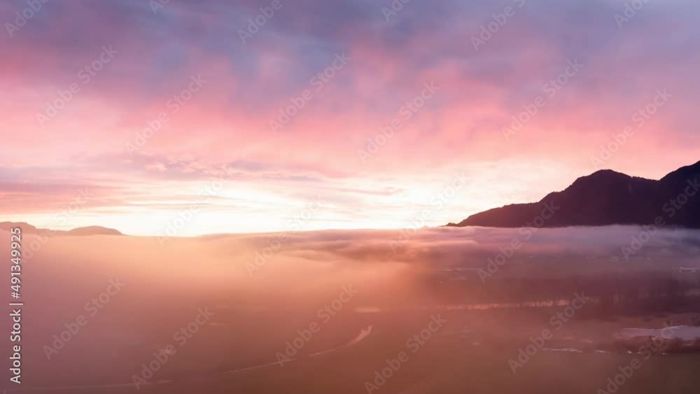Cinemagraph. Aerial View of Farm lands and Canadian Mountain Nature Landscape. Dramatic Winter Sunset. Located near Chilliwack and Abbotsford, British Columbia, Canada. Cinemagraph. Aerial View of Farm lands and Canadian Mountain Nature Landscape. Dramatic Winter Sunset. Located near Chilliwack and Abbotsford, British Columbia, Canada.