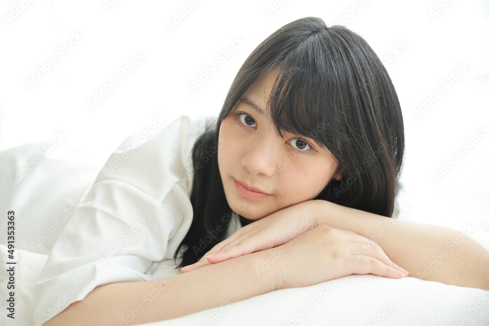 Beautiful young woman waking up in the morning at white bedroom Beautiful young woman waking up in the morning at white bedroom