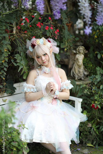 Beautiful young woman with white lolita dress with flowers garden Japanese fashion photo