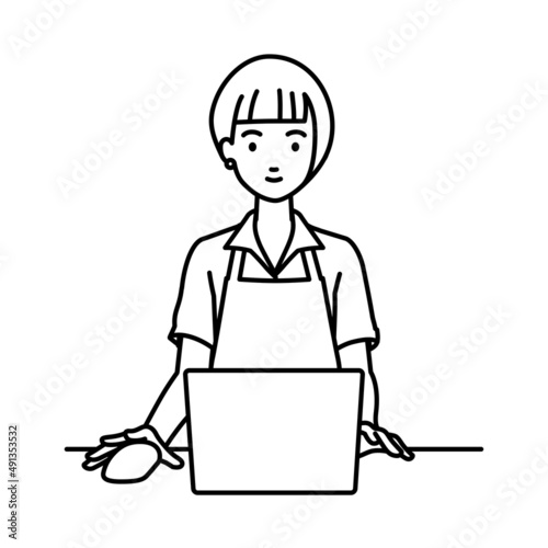 デスクで座ってPCを使っている店員の女性