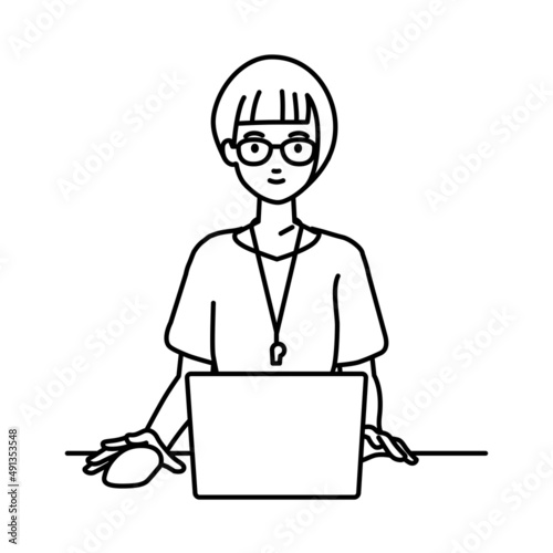 デスクで座ってPCを使っている教師の女性