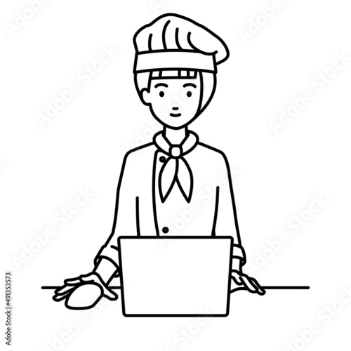 デスクで座ってPCを使っている調理師の女性