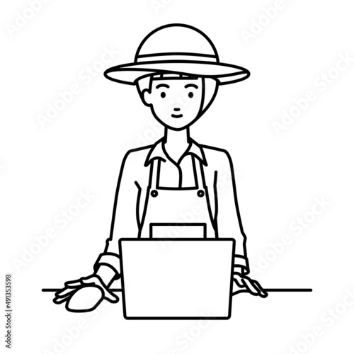 デスクで座ってPCを使っている農家の女性
