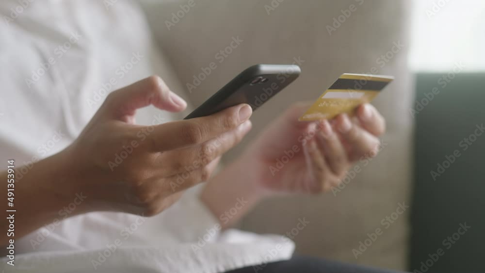 Hand of Asian women are buying online with a credit card on smartphone and doing online transaction at home Hand of Asian women are buying online with a credit card on smartphone and doing online transaction at home