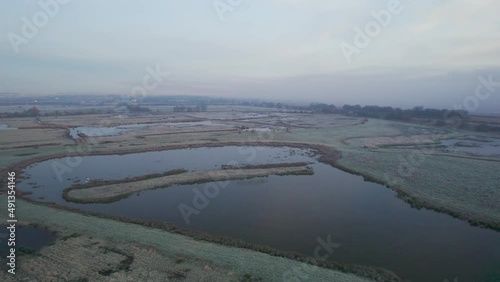 Misty Sunrise over Wetlands and meadows in RSPB Exminster and Powderham Marshe from a drone, Exeter, Devon, England photo