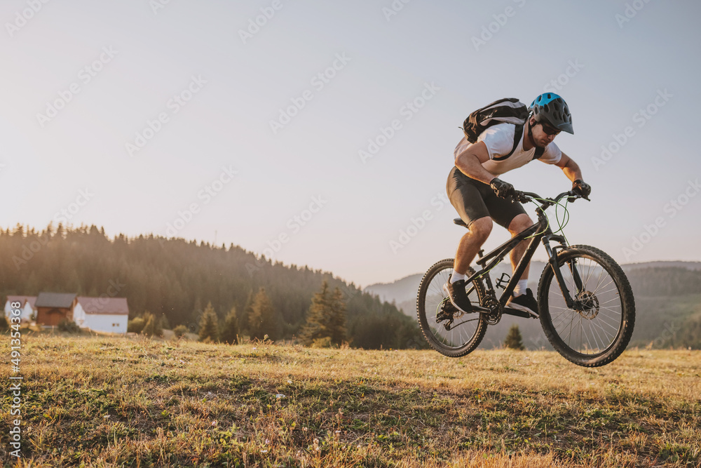 Naklejka premium Cyclist Riding the Bike on the Trail in the Forest. Man cycling on enduro trail track. Sport fitness motivation and inspiration. Extreme Sport Concept. Selective focus