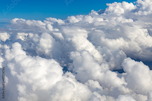 big cummulus clouds from above. flying with a plane through thick white clouds. shining blue sky with sunshine.  © 1take1shot