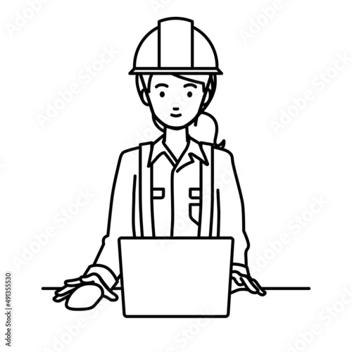 デスクで座ってPCを使っている工事現場の女性