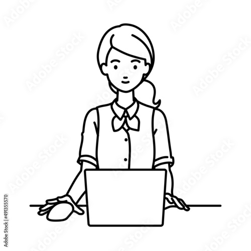 デスクで座ってPCを使っている事務員制服の女性