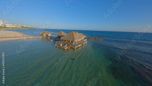 Thatched roof restaurant over ocean at Juan Dolio, Hemingway Beach; FPV drone photo