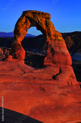 Twilight at the Delicate Arch and the distant La Sal Mountains, Arches National Park, Moab, Utah, USA