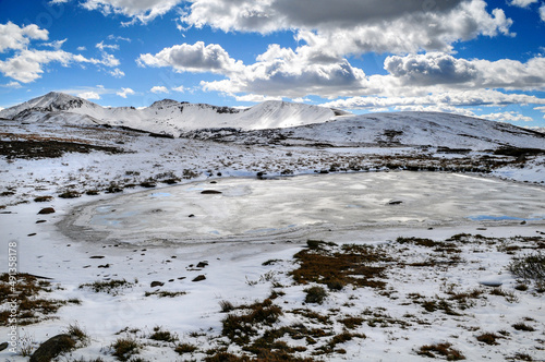 A frozen pond surrounded by early autumn snowfall on the mountains around Independence Pass, Colorado, USA